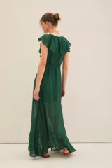 Vestido largo con estampado floral en tonos fucsia, negro y dorado, con escote en V cruzado, mangas cortas y lazo en la cintura.