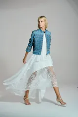 Vestido largo de encaje color negro, con escote halter y diseño asimétrico con transparencias.