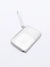 Billetera plateada rectangular con cierre de cremallera y correa de mano. Decorada con tachas redondas plateadas en los bordes.