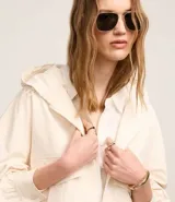 Campera oversized color beige con capucha ajustable, cierre frontal con cremallera, bolsillos cargo delanteros y puños con pliegues.