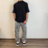 Pantalón jean cargo gris con efecto lavado, corte recto y bolsillos laterales.