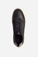 Zapatillas urbanas de cuero negro con detalles en gamuza, cordones negros y suela de goma color hueso.