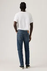 Pantalón de jean corte regular taper, con diseño de cinco bolsillos, cierre de botón y cremallera, y acabado en tono azul medio con efecto desgastado.