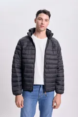 Campera negra capitoneada con capucha y cierre frontal.
