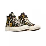 Championes Converse modelo Chuck 70 de caña alta, con diseño estampado de flores en tonos amarillos, rosas y verdes sobre base negra. Presenta el parche clásico de la marca en el lateral, puntera de goma y suela de plataforma en color crema.