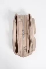 Bolso de mano de Bimba y Lola confeccionado en nylon color beige, con estructura blanda, doble asa superior y correa ajustable extraíble. Presenta dos bolsillos frontales con cierre, logo metálico frontal y cierre principal de cremallera.