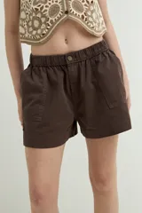 Short de denim azul oscuro con cintura elástica, bolsillos frontales aplicados y botón decorativo.
