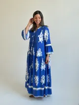 Vestido largo color azul con estampado ornamental en color blanco, escote en V con botones frontales y mangas tres cuartos con volados.
