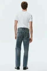 Jean de corte recto en denim de algodón rígido, con diseño de cinco bolsillos y acabado con efecto desgastado.