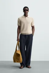 Polo de manga corta, corte regular fit, color verde oliva. Tejido de punto con textura acanalada vertical y cuello solapa con dos botones.