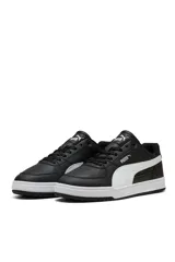 Championes deportivos Puma Caven III, color negro con franja lateral y suela en color blanco. Presentan perforaciones en la puntera y cordones negros.