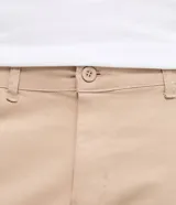 Pantalón slim de sarga lavada color marrón, con cierre de botón y cremallera, trabillas para cinturón y bolsillos laterales y traseros.