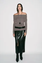 Falda midi de tiro alto con diseño de tubo, confeccionada en material con efecto piel. Presenta una abertura frontal en el bajo y cierre con cremallera oculta en la costura.
