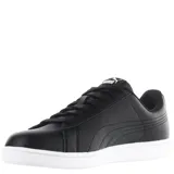 Championes urbanos Puma modelo Up, color negro con la icónica franja lateral en blanco y suela de goma blanca. Cuentan con cierre de cordones y logo de la marca en el lateral y la lengüeta.