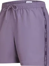 Short de baño Calvin Klein color lila, de largo medio, con cintura elástica ajustable con cordón, bolsillos laterales y traseros, forro de malla y logo de la marca en los laterales.