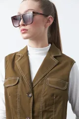 Chaleco de estilo utilitario color bordó con pespuntes blancos a contratono. Presenta solapas, cierre frontal con botones, bolsillos delanteros y un diseño estructurado.