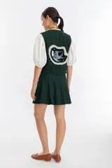 Chaleco verde oscuro de gamuza con terminaciones en cuero.