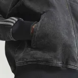 Campera Adidas Originals modelo Adicolor Denim Firebird, confeccionada en algodón denim de efecto desgastado. Presenta cuello alto, cierre frontal completo, bolsillos laterales y las clásicas franjas de la marca a lo largo de las mangas. Incluye el logotipo del Trifolio bordado en el pecho.