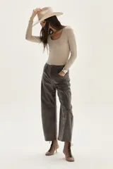 Top negro de manga larga, confeccionado en tela de lurex con calce al cuerpo y escote cuadrado.