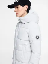 Parka larga acolchada color negro con capucha, cierre frontal con cremallera y bolsillos laterales.