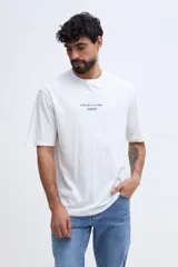 Remera oversize verde militar, confeccionada en 100% algodón, con cuello redondo y diseño relajado. Presenta un pequeño bordado frontal en tono naranja.