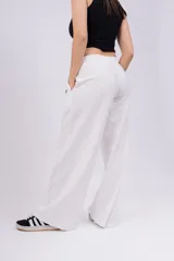 Pantalón de jogging de corte recto y tiro alto, color beige, con cintura elástica y logo bordado pequeño en la parte superior.