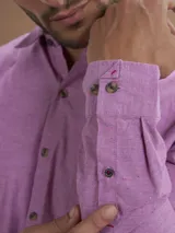 Camisa de manga larga color lila con cuello abotonado y bolsillo en el pecho.