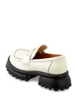 Mocasín color blanco acharolado con detalle de costuras negras y plataforma de goma negra con suela dentada.