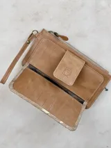 Billetera mediana de cuero color marrón con apliques dorados y cierre superior. Tiene correa de muñeca y bolsillo frontal con cierre de broche con logo de búho.