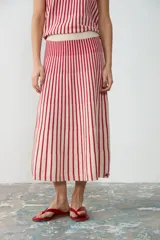 Pollera midi de tejido de punto a rayas verticales en color rojo y crudo, con cintura elástica.