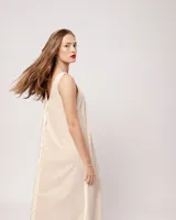 Vestido largo blanco de lino con escote en V y flecos de algodón en los bordes.