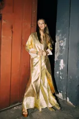 Tapado largo de cuero dorado, con cuello redondo, mangas largas y aberturas laterales.