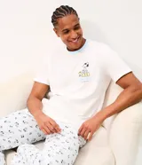Pijama largo para hombre confeccionado en algodón, compuesto por una remera de manga corta blanca con cuello redondo celeste y estampa frontal de Snoopy, y un pantalón largo celeste con estampado general de Snoopy y cintura elástica.