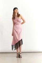 Vestido midi sin mangas color turquesa, con escote strapless y detalle de nudo frontal. El ruedo presenta un corte asimétrico con flecos negros largos.