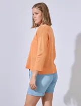 Buzo color salmón en tejido calado, marca Cable & Gauge. Cuello a la base, largo de manga 3/4. Ruedo y puño en tejido acanalado.