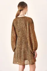 Vestido corto de mangas largas abullonadas con puños elásticos, escote en V profundo y corte holgado. Presenta un estampado animal print abstracto en tonos marrones y negros.