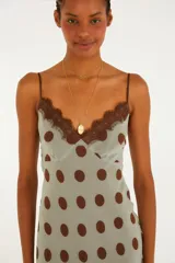Vestido midi de breteles finos color verde grisáceo con estampado de lunares marrones, escote en V con detalle de encaje marrón y silueta fluida.