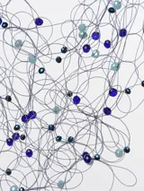 Collar de cuentas azules y celestes con hilos plateados y cierre de cordón negro.