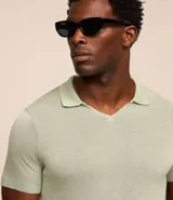 Remera polo masculina de punto color verde claro, con cuello en V y mangas cortas.