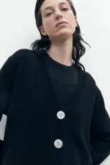 Cárdigan gris melange con cuello en V y cierre frontal con botones.