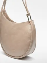 Cartera hobo color beige, de piel sintética con textura craquelada. Tiene un compartimento con cierre de clip magnético y un bolsillo interior con cierre de cremallera. El asa es tubular con pieza metálica y el logo está grabado.