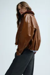 Pantalón de corte holgado y piernas rectas, confeccionado en tejido con textura de espiguilla. Presenta cintura elástica con cordón de ajuste, bolsillos laterales y bolsillos traseros decorativos.