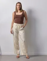 Pantalón palazzo color crudo de lyocell marca Nanette, con pretina elastizada, lazo de ajuste y bolsillos delanteros.