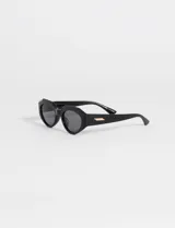 Lentes de sol con montura hexagonal color carey y lentes negras.