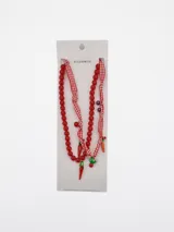 Collar doble de cuentas rojas y tiras de tela a cuadros vichy, con dijes colgantes de chiles y zanahorias.