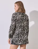 Blusa estampada en blanco y negro, marca Grand & Greene. Tiene cuello a la base, escote en V y abertura con botones. La manga es larga y amplia con detalle plisado.