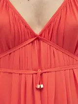 Vestido largo de crepe color rojo, con escote en V profundo, breteles finos ajustables con nudos y detalle de cordón ajustable en la cintura con terminales metálicas.