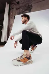 Championes urbanos New Balance modelo XC-72, con diseño de paneles en tonos beige, marrón y naranja. Presentan una suela de goma texturizada con diseño dividido y logo N en el lateral.