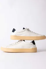 Championes urbanos de cuero blanco con suela de goma color caramelo y detalle de talón en color azul oscuro.