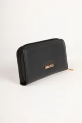 Billetera color crema con cierre de cremallera y apliques de tachas doradas en forma de corazón.